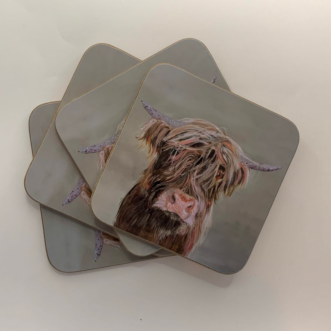A set of four Highland Cow Coasters. Etsy