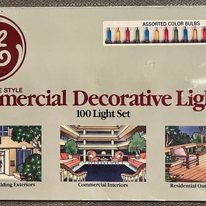 May include: A box of GE Miniature Style Commercial Decorative Lighting, a 100 light set with assorted color bulbs. The box shows three illustrations of different settings where the lights could be used: a hotel/office building exterior, a commercial interior, and a residential outdoor landscaping scene.