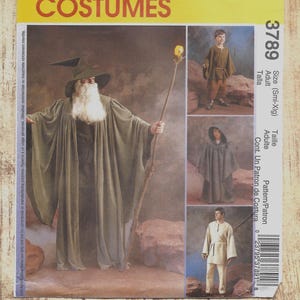 May include: McCall's Costumes sewing pattern 3789 for adult sizes small to extra-large. The envelope features illustrations of a wizard in a green robe and hat with a staff, a hooded cloak, a tunic with pants, and a simple shirt and pants set.