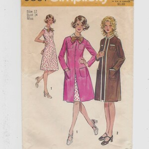 May include: Simplicity sewing pattern number 9891 for a dress and coat. The pattern is for sizes 12 and bust 34. The pattern shows three different styles of dresses, one with polka dots, one with a pink coat, and one with a brown coat.