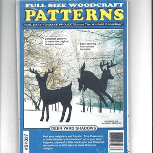 May include: A plastic-wrapped package of full-size woodcraft patterns for deer yard shadows by The Winfield Collection. The cover features a snowy forest scene with two black deer silhouettes, text, and a barcode. The item number is #SH327.