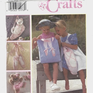 May include: Simplicity Crafts sewing pattern featuring ballet-themed projects. The pattern includes instructions for a tote bag, ballet slippers, and a teddy bear in a tutu. The image shows two young girls with the tote bag and a ballet slipper bag.