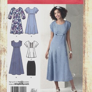 May include: Simplicity sewing pattern 2249 featuring a woman in a blue dress. The pattern includes illustrations of various dress designs, including a floral print dress, a solid blue dress, and a checkered dress. The pattern size is BB 20W-28W.