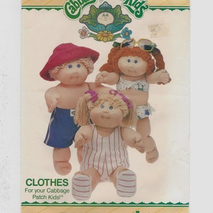 May include: A vintage sewing pattern for Cabbage Patch Kids clothes. The pattern shows three Cabbage Patch Kids dolls wearing different outfits: a boy in blue swim trunks, a girl in a pink and white striped swimsuit, and a girl in a pink bikini. The pattern is labeled "Cabbage Patch Kids" and "Butterick" and has the number 360.