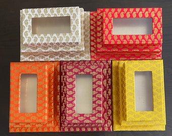 May include: Set of six decorative boxes with intricate paisley patterns in shades of white, red, orange, and yellow. Each box has a rectangular window opening.