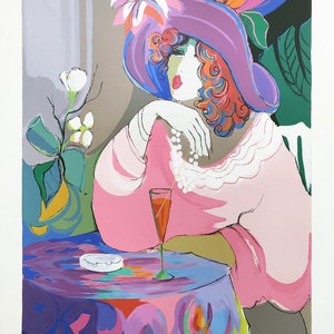 Könnte beinhalten: Eine Frau in einem rosa Kleid und einem lila Hut mit Blumenmuster sitzt an einem Tisch mit einem Glas Rotwein. Der Tisch hat eine lila Tischdecke mit einem bunten abstrakten Muster.
