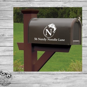 May include: A brown mailbox with a white vinyl decal featuring a fish and the letter "N" in a circle. The mailbox also has the address "56 Nerdy Noodle Lane" printed on it.