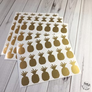 May include: A set of four sheets of gold pineapple stickers. Each sheet has 25 pineapple stickers.