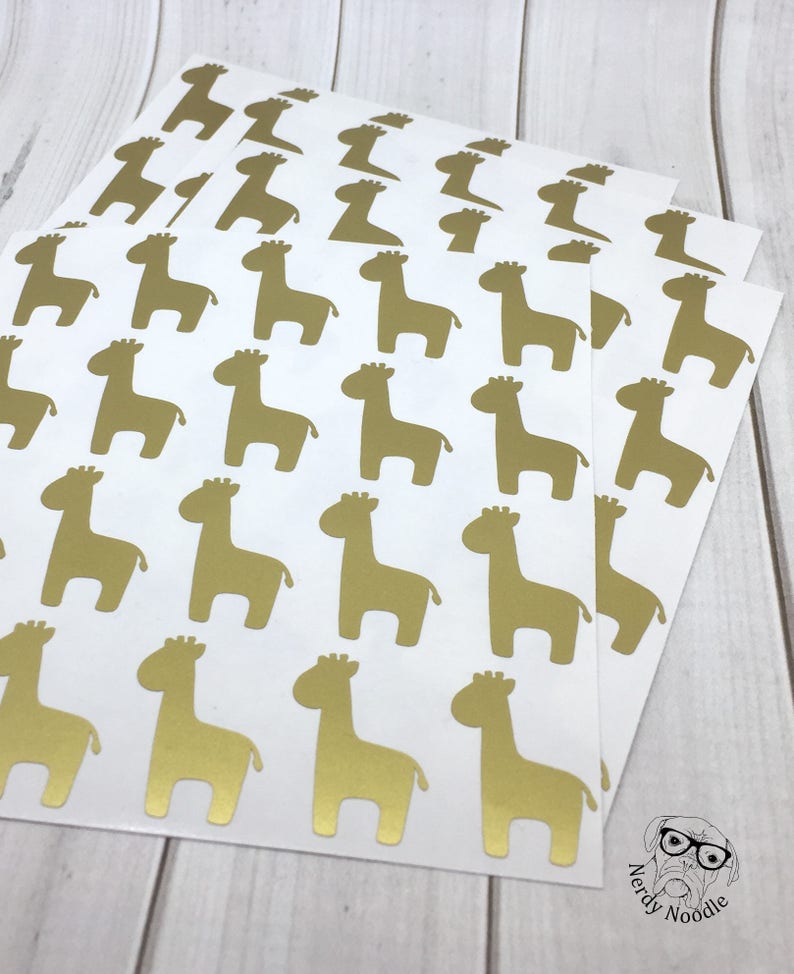 May include: Sheets of white paper with gold giraffe stickers. The stickers are arranged in a grid pattern.