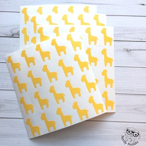 May include: Three sheets of white paper with a repeating pattern of yellow giraffe silhouettes.