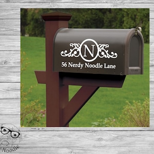 May include: A brown mailbox with a white monogram sticker featuring the letter "N" in a circle with decorative swirls. The address "56 Nerdy Noodle Lane" is printed below the monogram.