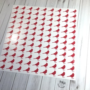 May include: A sheet of white paper with a repeating pattern of red cardinal bird silhouettes.