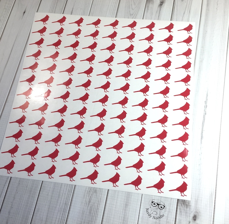 May include: A sheet of white paper with a repeating pattern of red cardinal bird silhouettes.