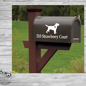 May include: A brown mailbox with a white silhouette of a Labrador Retriever with a heart on its chest. The mailbox has the address "310 Strawberry Court" printed on it.
