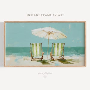 Può includere: Una stampa artistica incorniciata di una scena sulla spiaggia con due sedie a sdraio a righe verdi e bianche e un ombrellone bianco. L'opera d'arte è incorniciata in una cornice di legno chiaro. Il testo "INSTANT FRAME TV ART" è in alto.