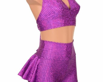 Puede incluir: Top morado de halter y pantalones cortos de cintura alta con un patrón de escamas de sirena. Los pantalones cortos tienen un detalle de volantes en el lateral.
