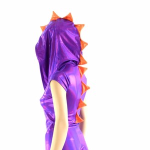 May include: Purple and orange hooded bodysuit with a dragon-like tail. The bodysuit is made of shiny fabric and has short sleeves.