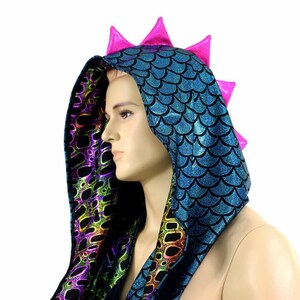 May include: A hooded garment with a blue and green iridescent scale pattern and a pink spiky design on the hood.