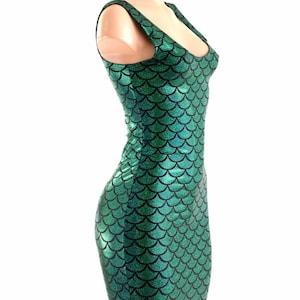 Puede incluir: Un vestido verde sin mangas con un patr&oacute;n de escamas de sirena. El vestido es entallado y tiene un escote redondo.