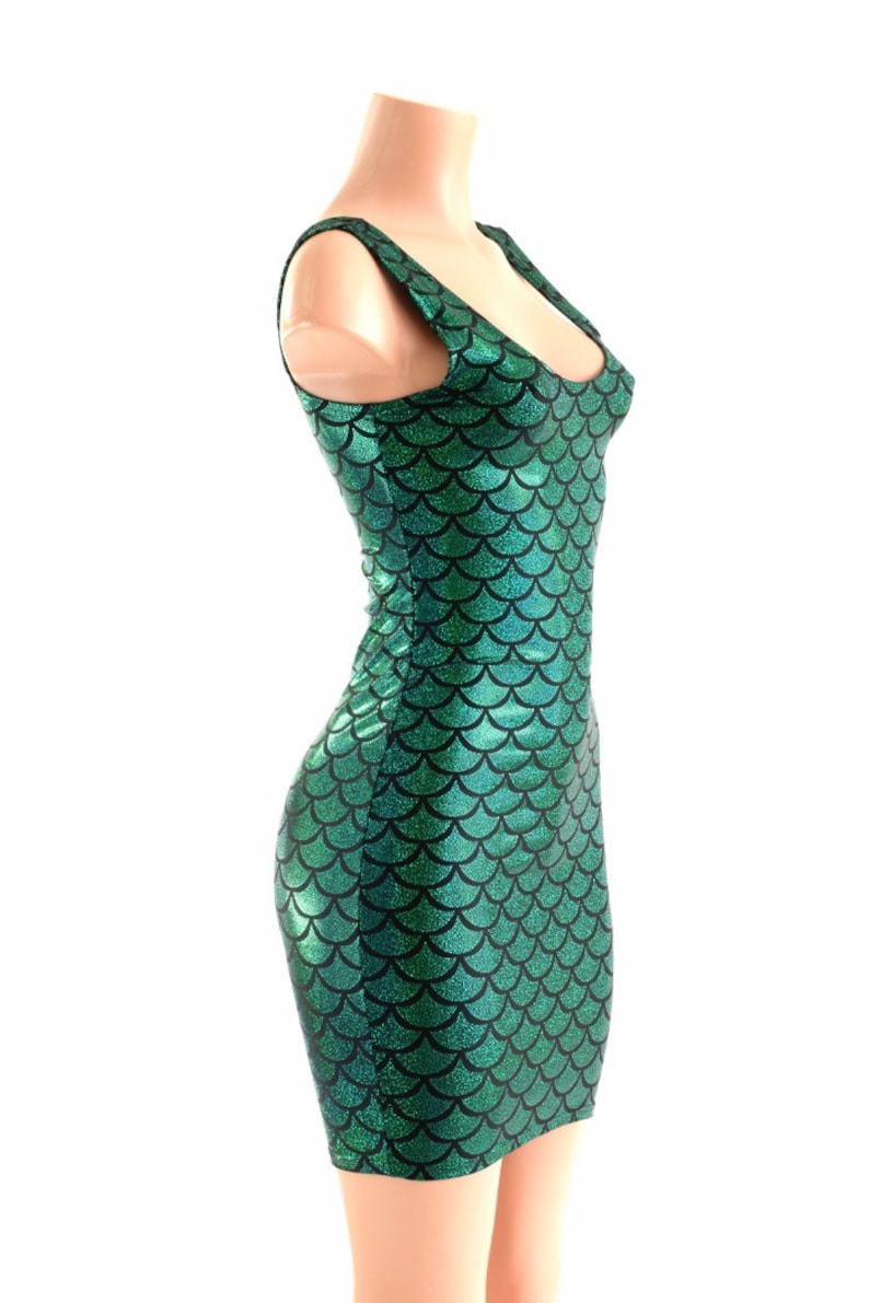 Puede incluir: Un vestido verde sin mangas con un patr&oacute;n de escamas de sirena. El vestido es entallado y tiene un escote redondo.