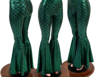 Puede incluir: Pantalones de campana de talle alto en tela verde metálica con un patrón de escamas negro repetitivo. La prenda tiene una silueta ajustada en las caderas y los muslos, que se transforma en aberturas anchas y acampanadas en el dobladillo.