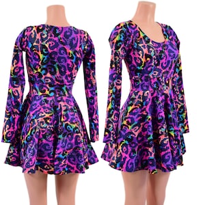 May include: Two dresses with long sleeves and a flared skirt are displayed. The dresses feature a vibrant leopard print in shades of purple, pink, blue, and yellow. The dresses are on mannequins.