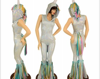 May include: A silver iridescent jumpsuit with a unicorn hood and tail. The jumpsuit has a sleeveless design and features a rainbow fringe trim on the legs and tail. The hood has a white horn and rainbow mane.