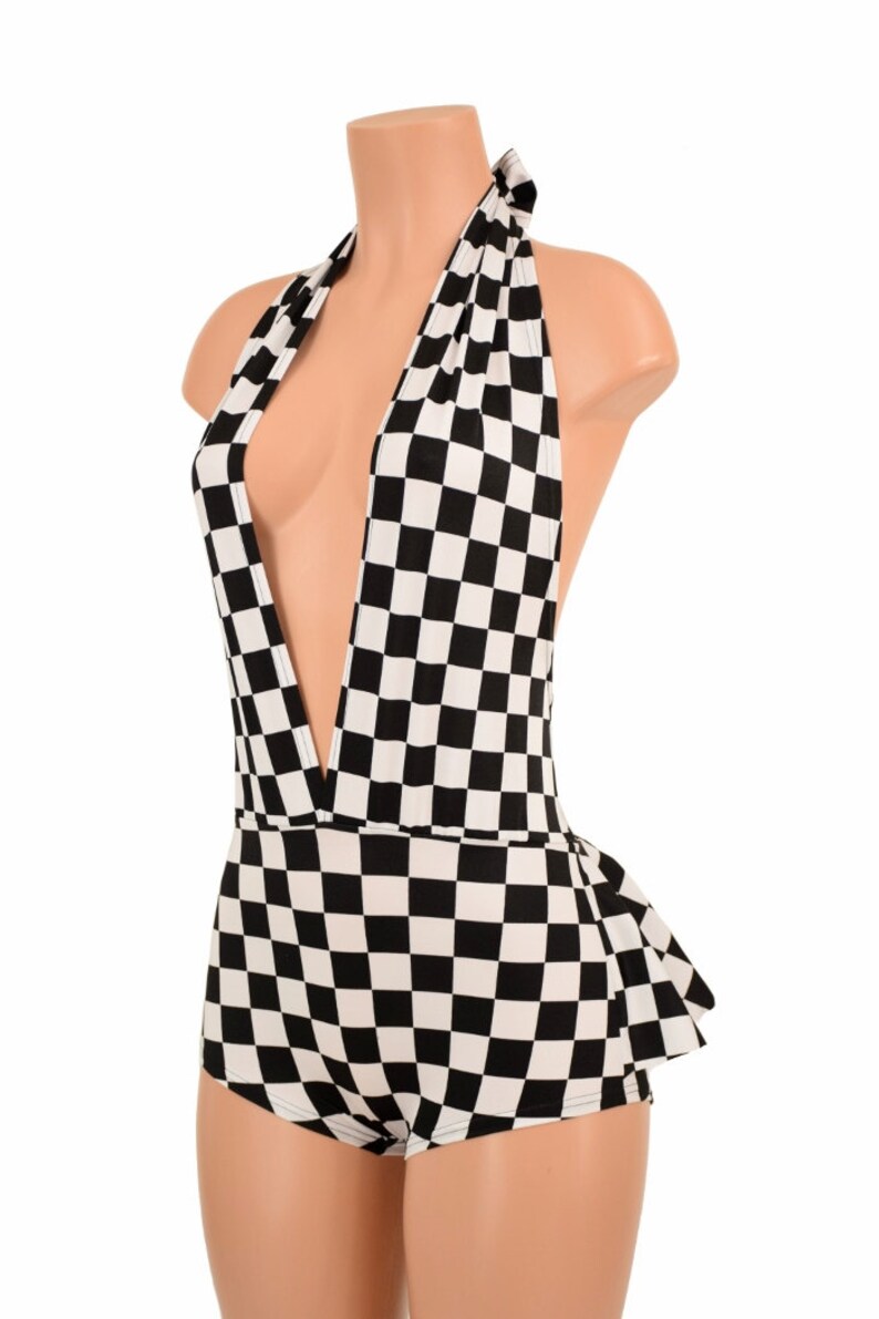May include: A black and white checkered halter-style bodysuit featuring a deep plunging neckline, a tie closure at the back of the neck, and a ruffled peplum detail at the waistline, displayed on a mannequin torso.