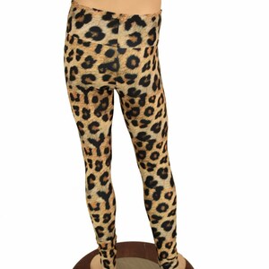 May include: Brown and black leopard print leggings on a mannequin. The leggings are made of a stretchy fabric and have a high waist.
