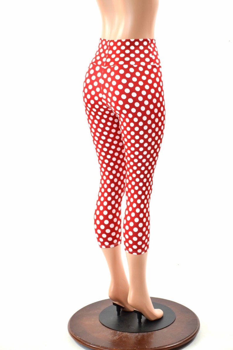 May include: Red and white polka dot leggings with a high waist. The leggings are cropped and end just below the knee.