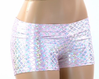 Puede incluir: Shorts de booty de color rosa e iridiscente con estampado de escamas de sirena. Los shorts están hechos de una tela elástica y brillante y tienen un ajuste de cintura alta.