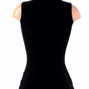 May include: A black sleeveless shirt with a mock neck.