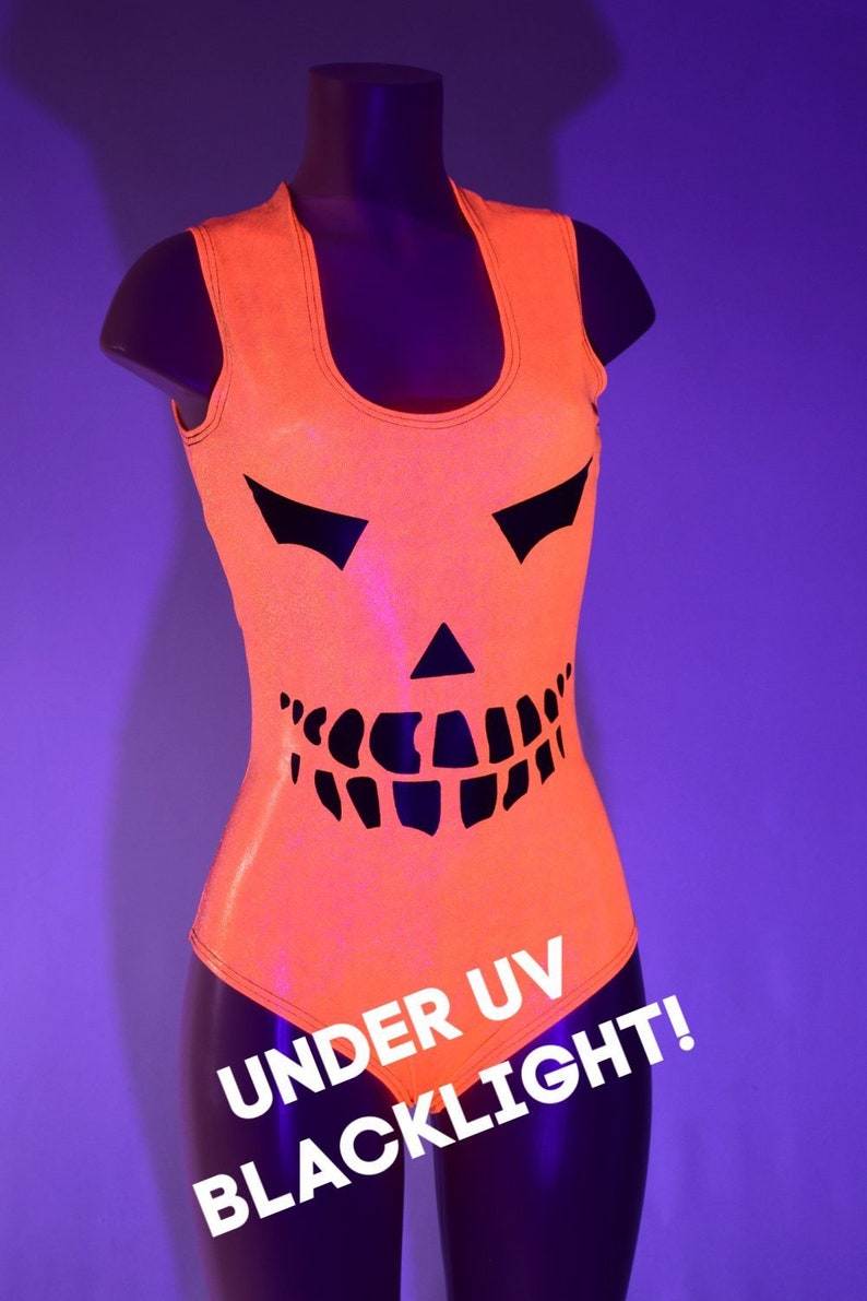 May include: Orange sleeveless bodysuit with a black jack-o'-lantern design. The text "UNDER UV BLACKLIGHT!" is printed on the bottom of the bodysuit.