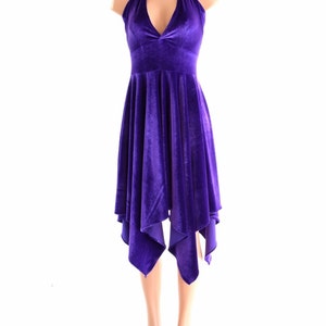 May include: A purple velvet halter dress with a deep V-neckline and a flowing, asymmetrical skirt.