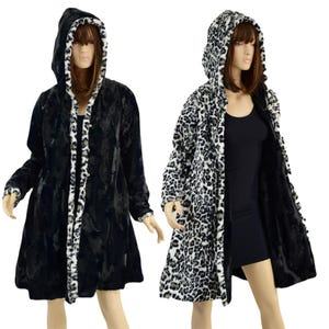 May include: A black and white faux fur coat with a leopard print on one side and a solid black side. The coat has a hood and a long, flowing silhouette.