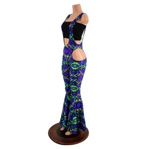May include: Black and neon green, purple, and blue patterned overalls with a cutout on the side. The overalls have suspenders and a flared leg.