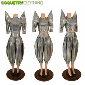 May include: A silver iridescent two-piece outfit with a cropped top and high-waisted pants. The top has exaggerated shoulder pads and the pants are a loose, baggy style.