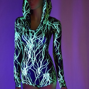 May include: A black and green hooded bodysuit with a lightning bolt pattern. The bodysuit is made of a shiny, stretchy fabric.