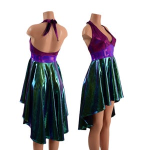 May include: A high-low halter dress with a purple and green iridescent fabric. The dress has a fitted bodice and a flowing skirt.