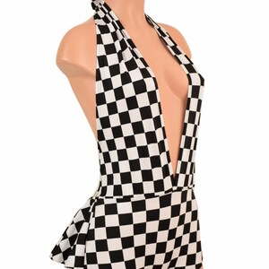 May include: A black and white checkered halter bodysuit featuring a deep plunging neckline and a ruffled peplum detail at the waist. The garment is displayed on a mannequin, showcasing the repeating square pattern across the entire piece.