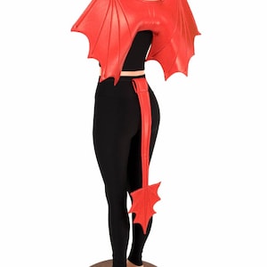 May include: Red dragon wings and tail costume accessory set. The wings are large and have a textured, leathery look. The tail is long and has a pointed tip.