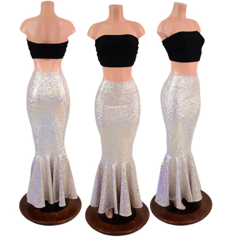 May include: A black strapless tube top paired with a high-waisted, floor-length mermaid skirt featuring a shimmering, iridescent silver scale pattern. The skirt is fitted through the hips and thighs, flaring out at the bottom into a ruffled hem.