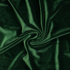 May include: A close-up of a deep green velvet fabric with soft folds and wrinkles.