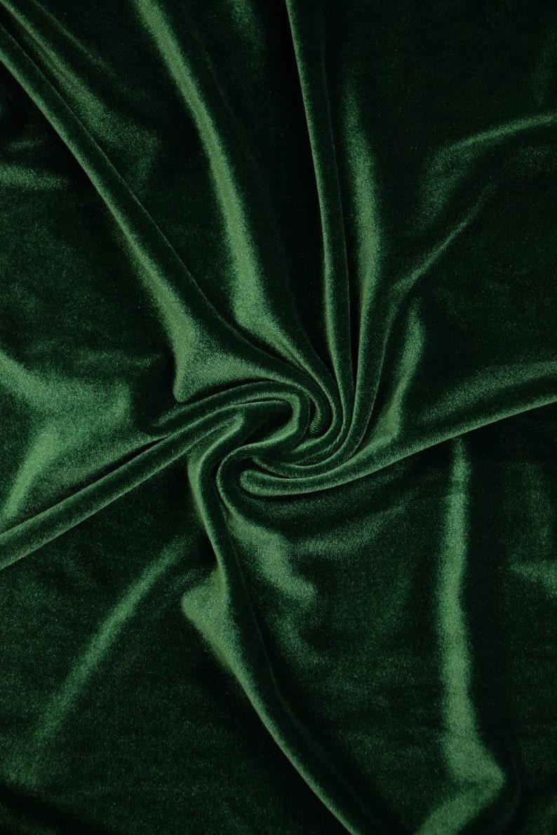 May include: A close-up of a deep green velvet fabric with soft folds and wrinkles.