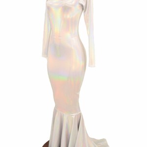 May include: A white iridescent mermaid-style dress with long sleeves and a fitted bodice. The dress has a flowing skirt with a mermaid tail design.