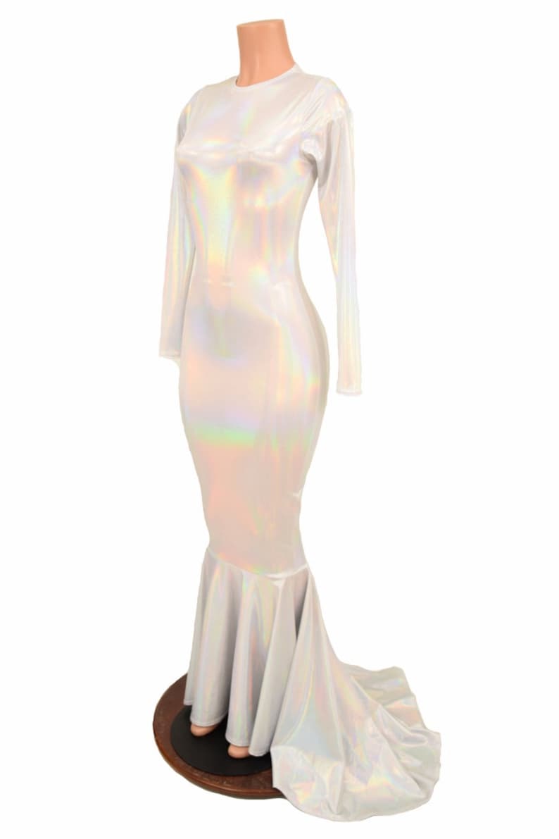 May include: A white iridescent mermaid-style dress with long sleeves and a fitted bodice. The dress has a flowing skirt with a mermaid tail design.