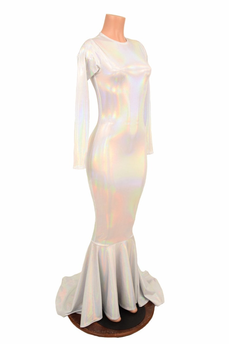 May include: A white iridescent mermaid-style dress with long sleeves and a fitted bodice. The dress has a flowing skirt with a mermaid tail design.