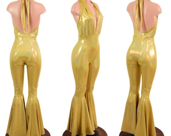 May include: A gold, shimmering jumpsuit with a halter neck and flared legs. The one-piece garment is displayed on a mannequin, showcasing its form-fitting design and open back. The jumpsuit has a metallic sheen.