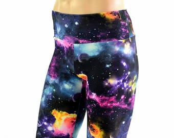 May include: Biker shorts with a vibrant galaxy print featuring shades of blue, purple, pink, and yellow. The shorts have a high waistband and a form-fitting design. The overall theme is space and celestial bodies.