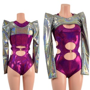 May include: Two-piece metallic bodysuit in a vibrant purple hue. The bodysuit features cut-out details with silver ring accents and is paired with a silver, long-sleeved bolero with padded shoulders. The fabric has a shimmering, holographic effect.